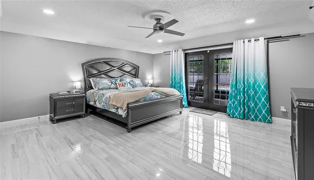 a spacious bedroom with a bed a chandelier and a large window