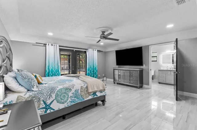 a spacious bedroom with a bed and a flat screen tv