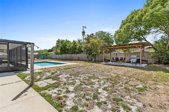 a view of a house with backyard and a tree