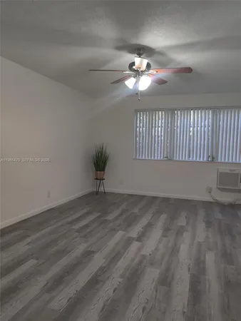 a view of an empty room with a chandelier fan