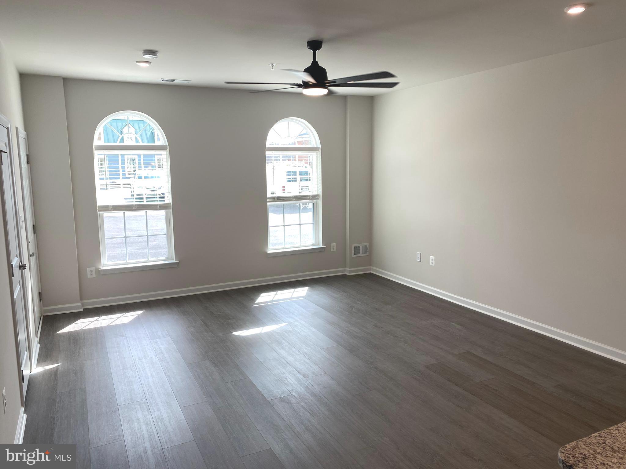 7911 Independence Drive, Unit 1C Spotsylvania, VA 22553 - Photo 4 of 35 an empty room with wooden floor chandelier and windows