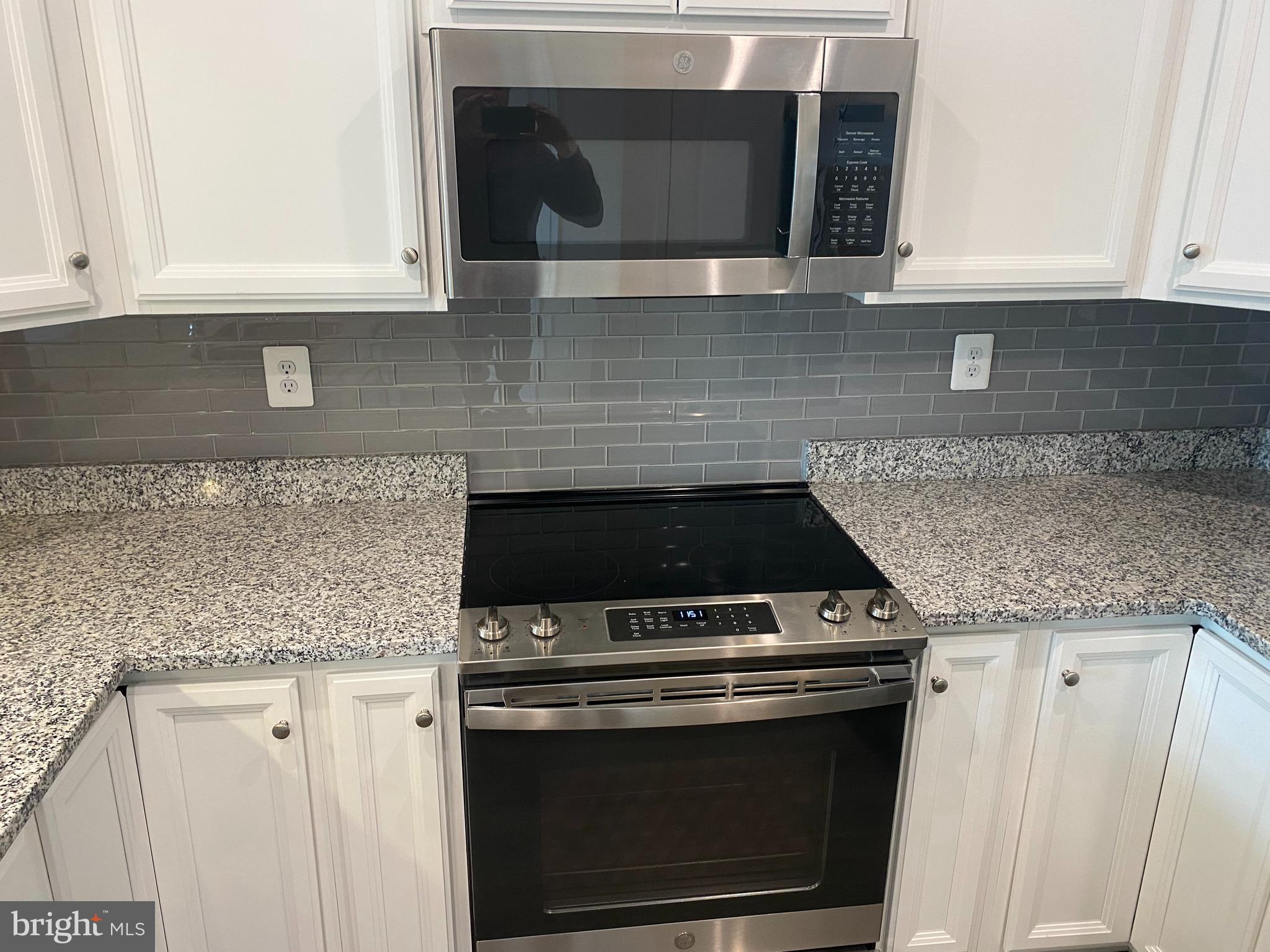 7911 Independence Drive, Unit 1C Spotsylvania, VA 22553 - Photo 8 of 35 a kitchen with granite countertop white cabinets and stainless steel appliances