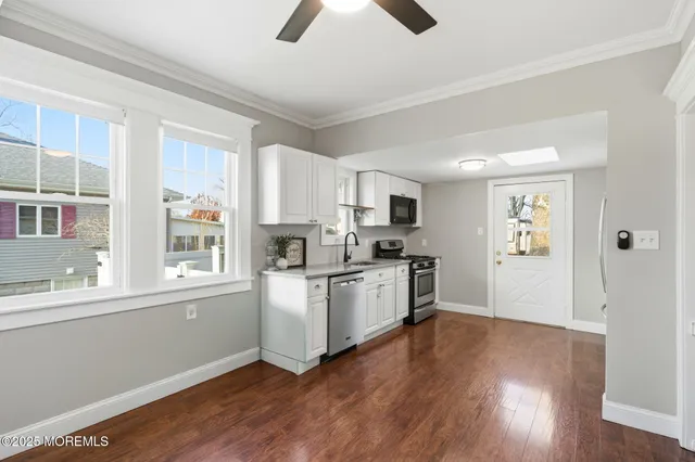 a kitchen with stainless steel appliances granite countertop a refrigerator a stove top oven a sink and dishwasher with wooden floor