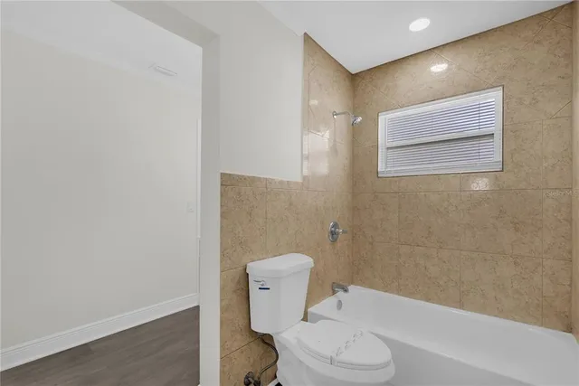 a white toilet sitting next to a bath tub