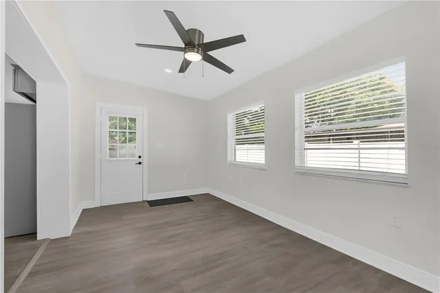 a view of a big room with wooden floor and windows