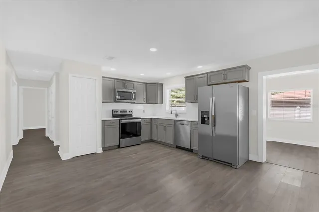 a large kitchen with a refrigerator and a stove top oven