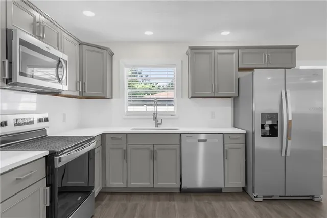 a kitchen with stainless steel appliances granite countertop a refrigerator and a stove top oven
