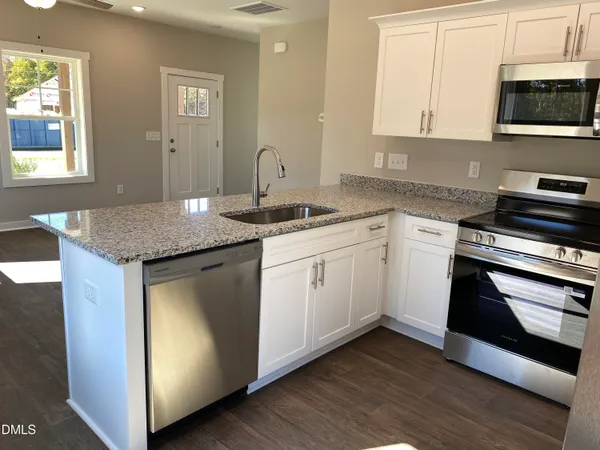 a kitchen with stainless steel appliances granite countertop a sink and a stove