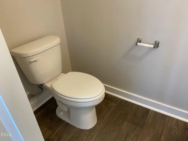 a white toilet sitting next to a white cabinet