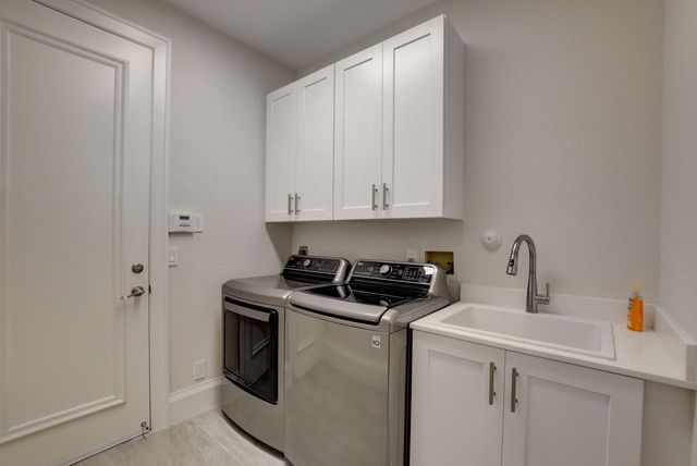 a kitchen with granite countertop a sink cabinets and stainless steel appliances