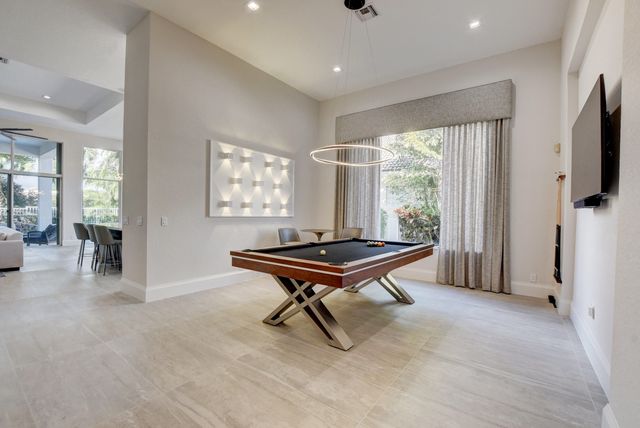a bedroom with a bed a flat screen tv and a chandelier