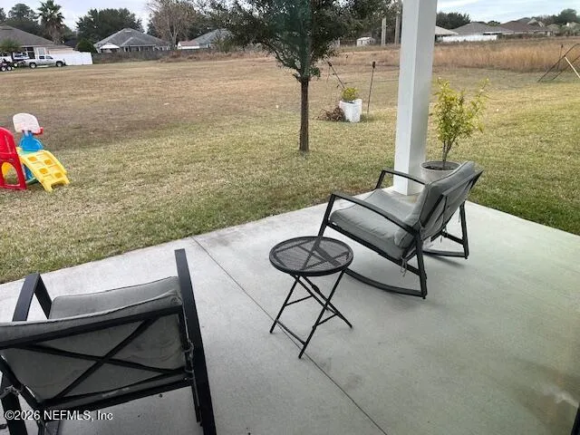 a view of a patio with lawn chairs floor to ceiling window and lake view