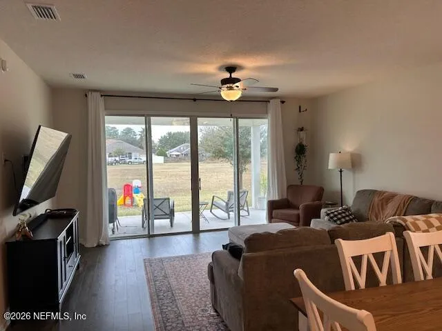 a living room with furniture a flat screen tv and a floor to ceiling window
