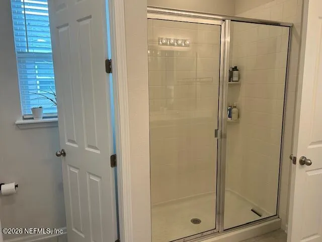 a bathroom with a glass shower door