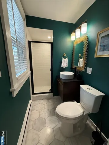 an empty room with wooden floor closet and windows