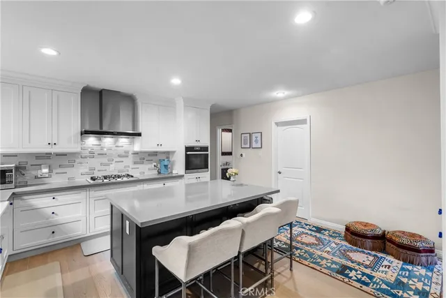 a kitchen with granite countertop a stove a sink dishwasher and a refrigerator with wooden floor