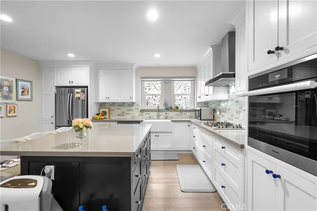 a kitchen with white cabinets appliances and a sink