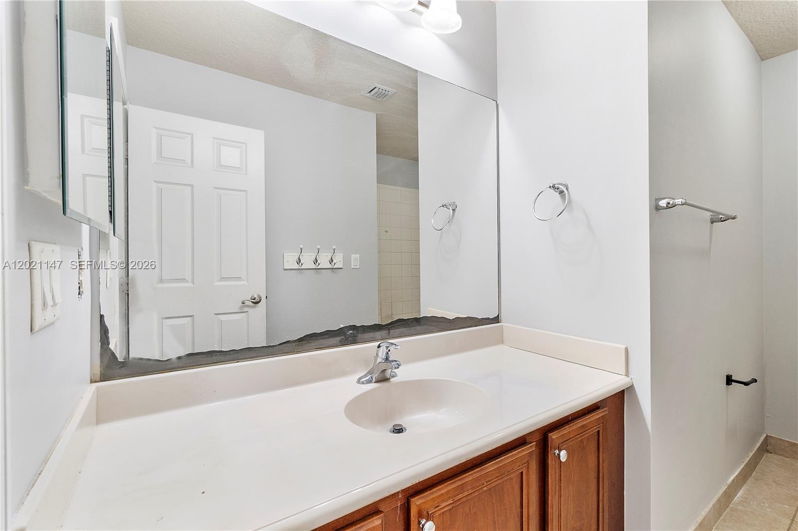 5930 Abbey Road Tamarac, FL 33321 - Photo 12 of 26 a bathroom with a sink and a mirror