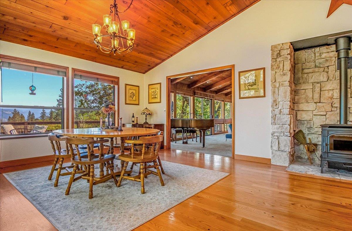 5617 Indian Hills Road Murphys, CA 95247 - Photo 11 of 80 a dining room with wooden floor a chandelier a glass table and chairs