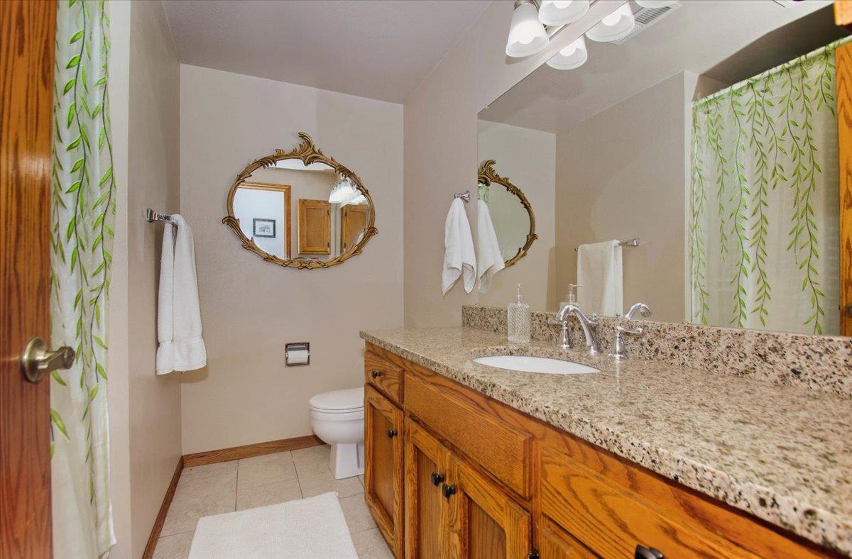 5617 Indian Hills Road Murphys, CA 95247 - Photo 26 of 80 a bathroom with a granite countertop sink and a mirror
