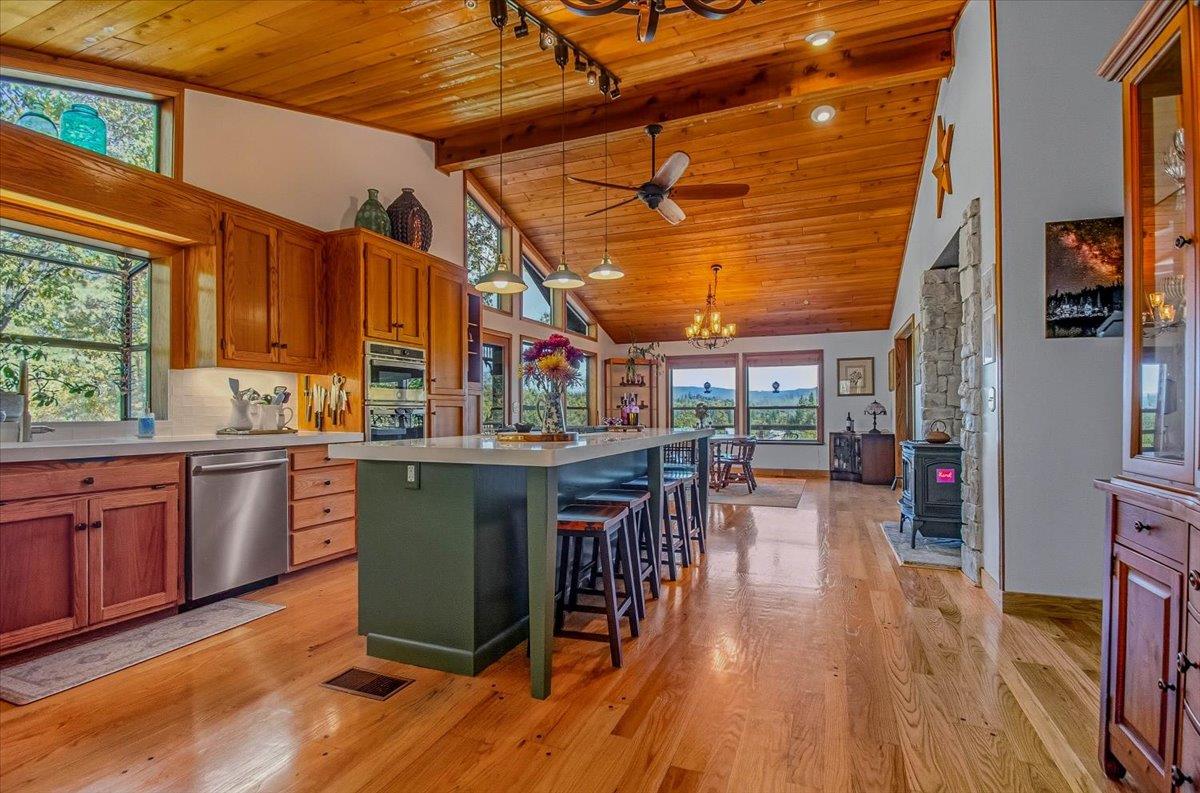 5617 Indian Hills Road Murphys, CA 95247 - Photo 6 of 80 a kitchen with stainless steel appliances granite countertop a stove a refrigerator a dining table and chairs with wooden floor