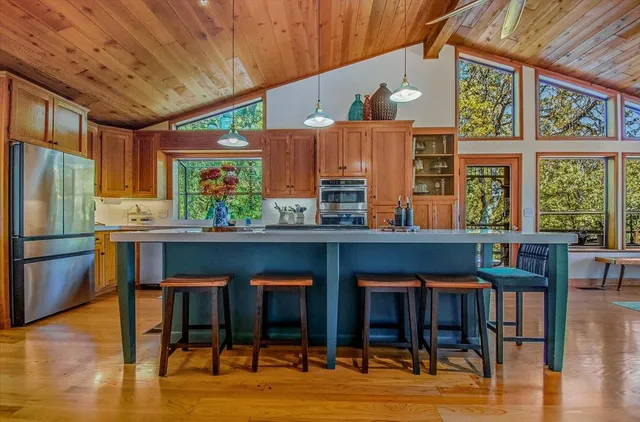 a dining room with wooden floor a chandelier a glass table and chairs