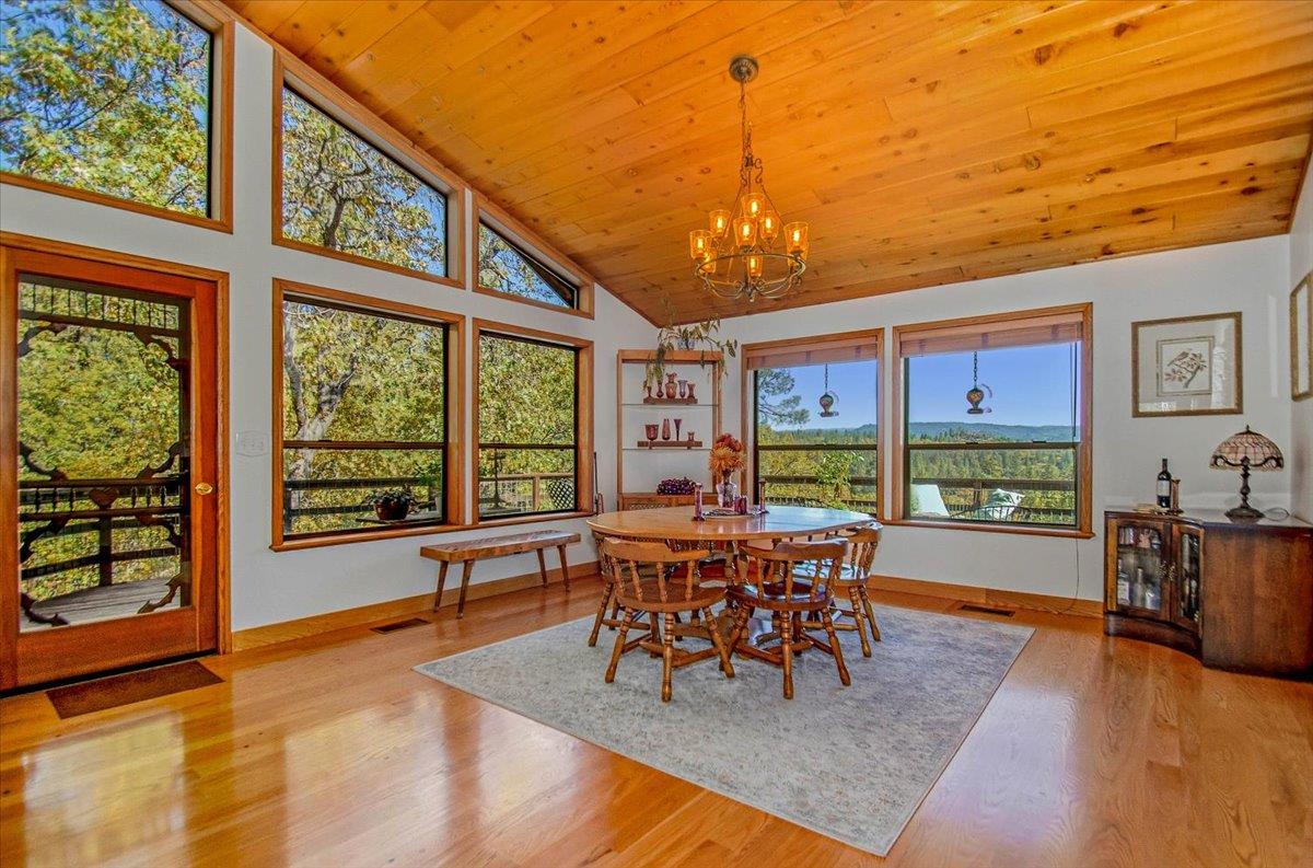 5617 Indian Hills Road Murphys, CA 95247 - Photo 10 of 80 a view of a dining room with furniture large windows and wooden floor