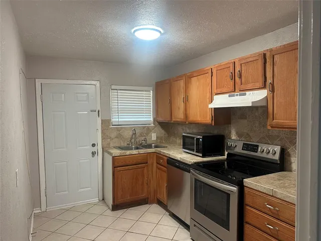a kitchen with a sink stove and cabinets