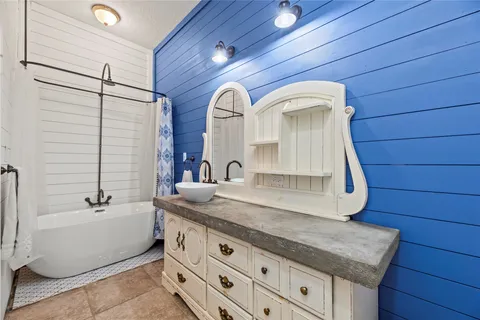 a bathroom with a granite countertop sink and a bathtub