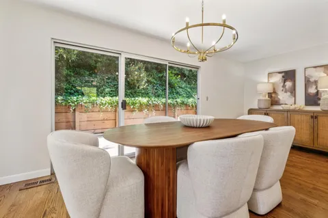 a dining room with furniture a chandelier and wooden floor