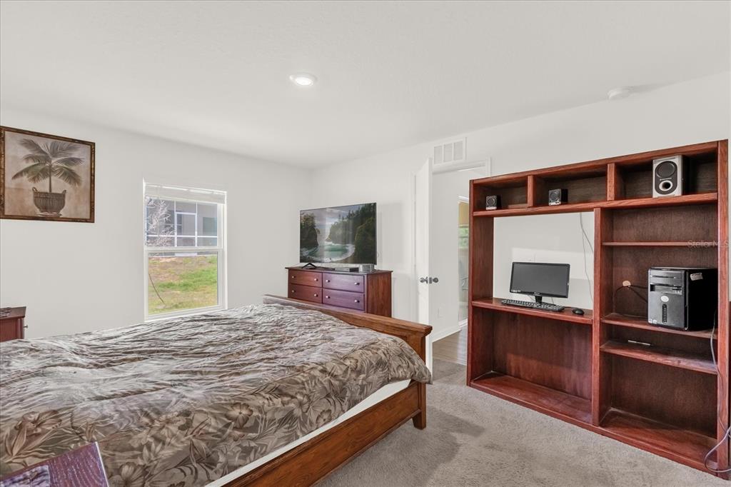 2134 Rio Grande Canyon Loop Poinciana, FL 34759 - Photo 13 of 22 a bedroom with a large bed and a tv on a dresser