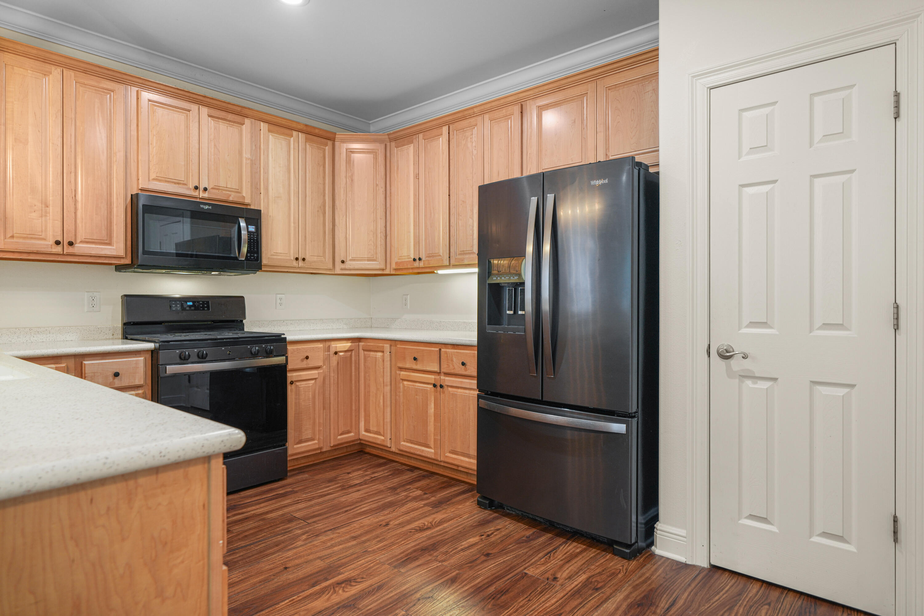 4116 Callaway Drive Niceville, FL 32578 - Photo 20 of 53 a kitchen with a refrigerator stove and wooden cabinets