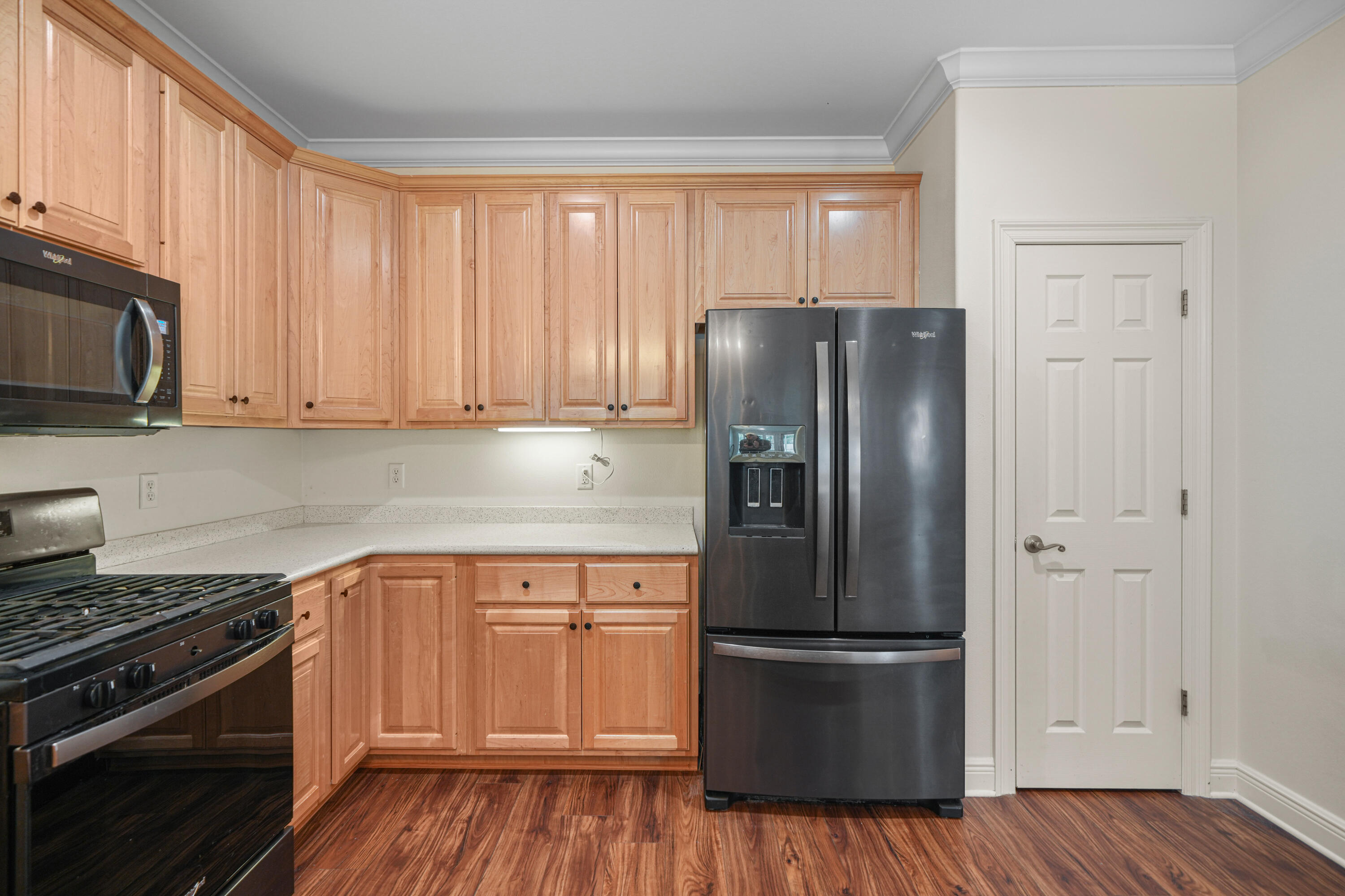 4116 Callaway Drive Niceville, FL 32578 - Photo 22 of 53 a kitchen with a refrigerator stove and wooden cabinets