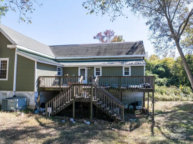 a view of a house with a wooden deck and furniture