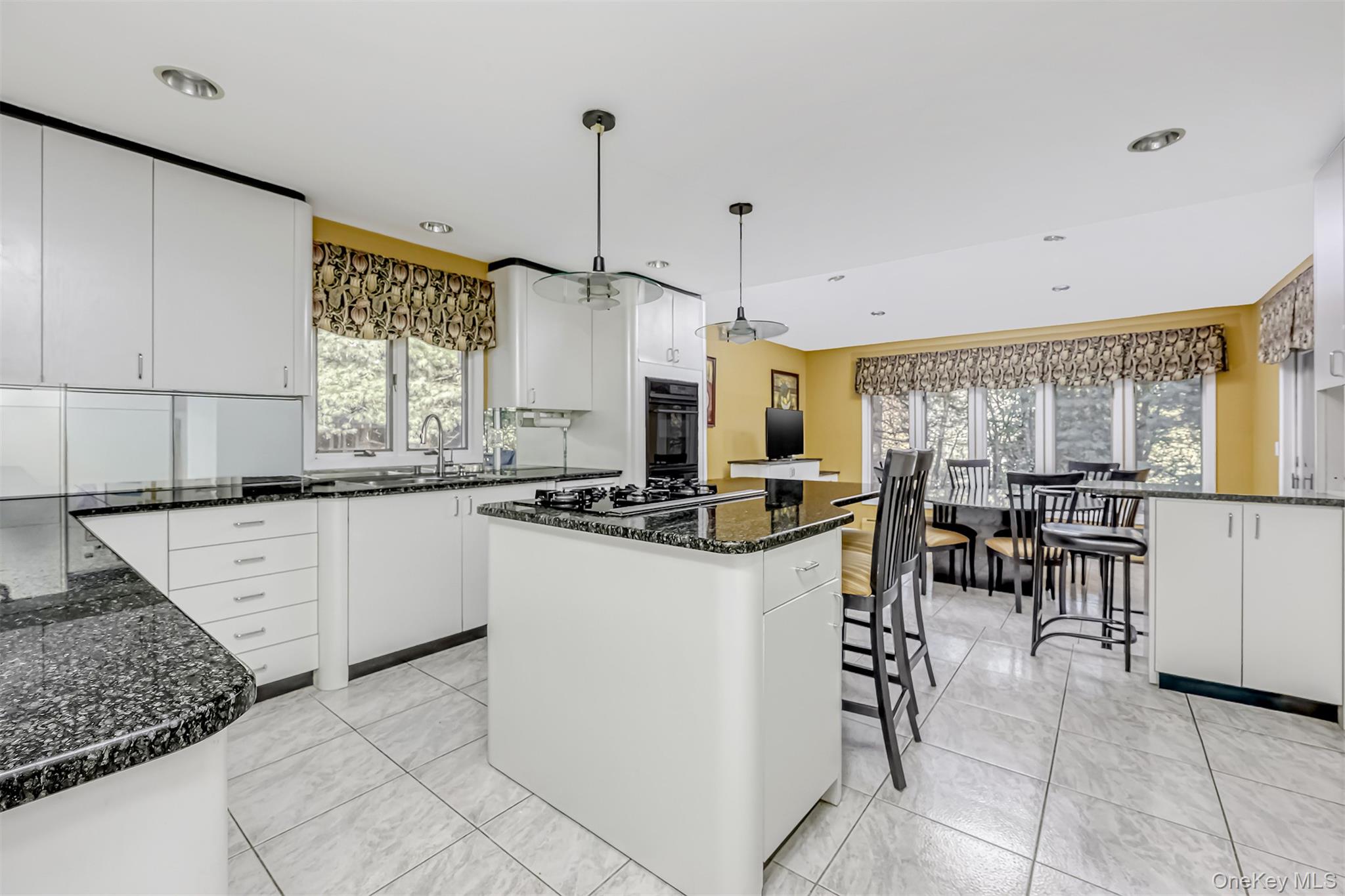 8 Kings Gate Road Suffern, NY 10901 - Photo 9 of 23 a kitchen with stainless steel appliances kitchen island granite countertop a stove a sink a dining table and chairs