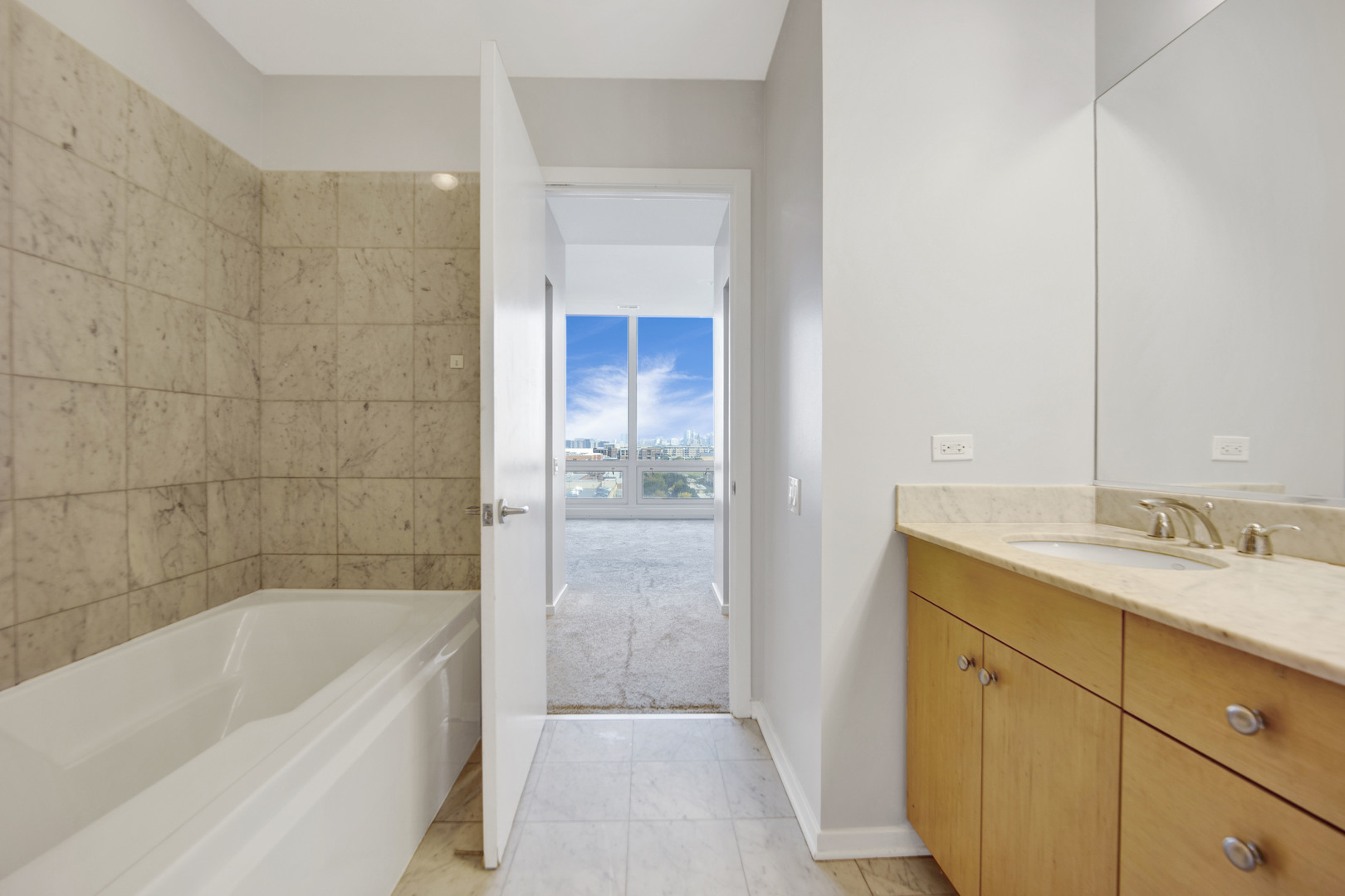 Undisclosed Address Chicago, IL 60654 - Photo 14 of 22 a bathroom with a granite countertop sink a mirror bathtub and shower