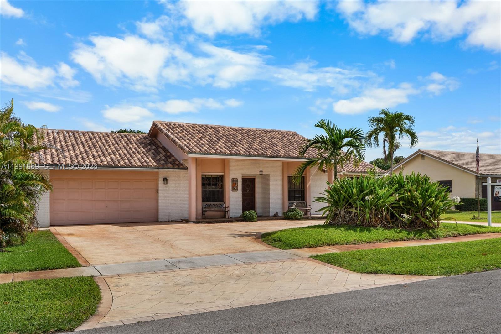5171 Southwest 20th Street Plantation, FL 33317 - Photo 2 of 30 a front view of a house with a garden and pathway