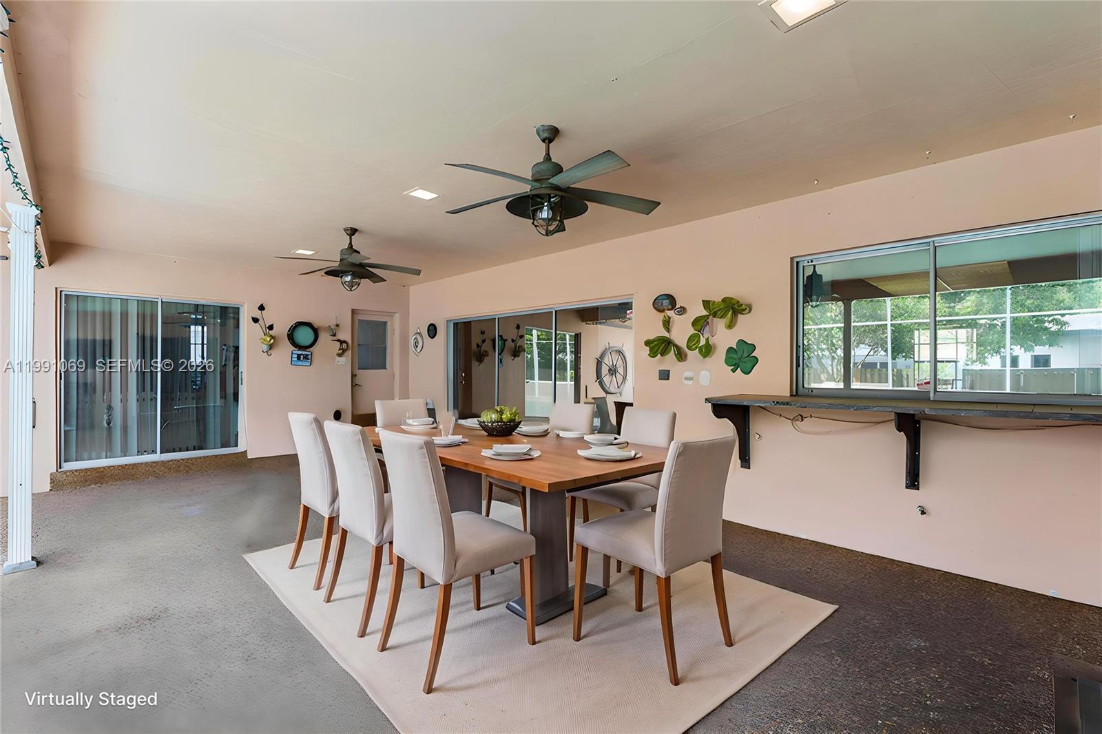 5171 Southwest 20th Street Plantation, FL 33317 - Photo 22 of 30 a dining room with furniture a chandelier and a large window