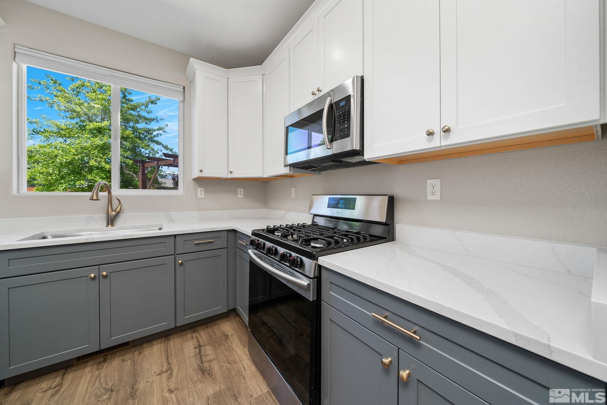2270 Big Trail Circle Reno, NV 89521 - Photo 5 of 40 a kitchen with stainless steel appliances white cabinets and a stove top oven
