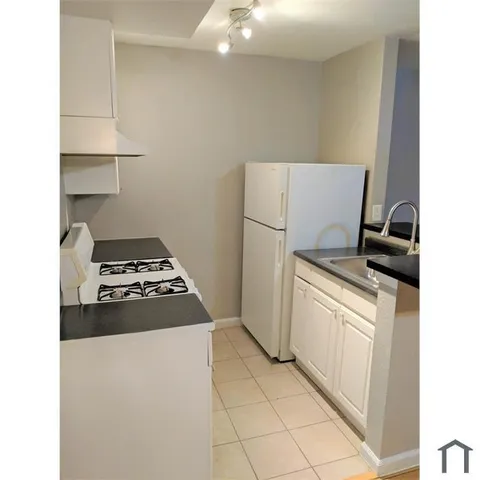 a kitchen with a stove top oven and cabinets