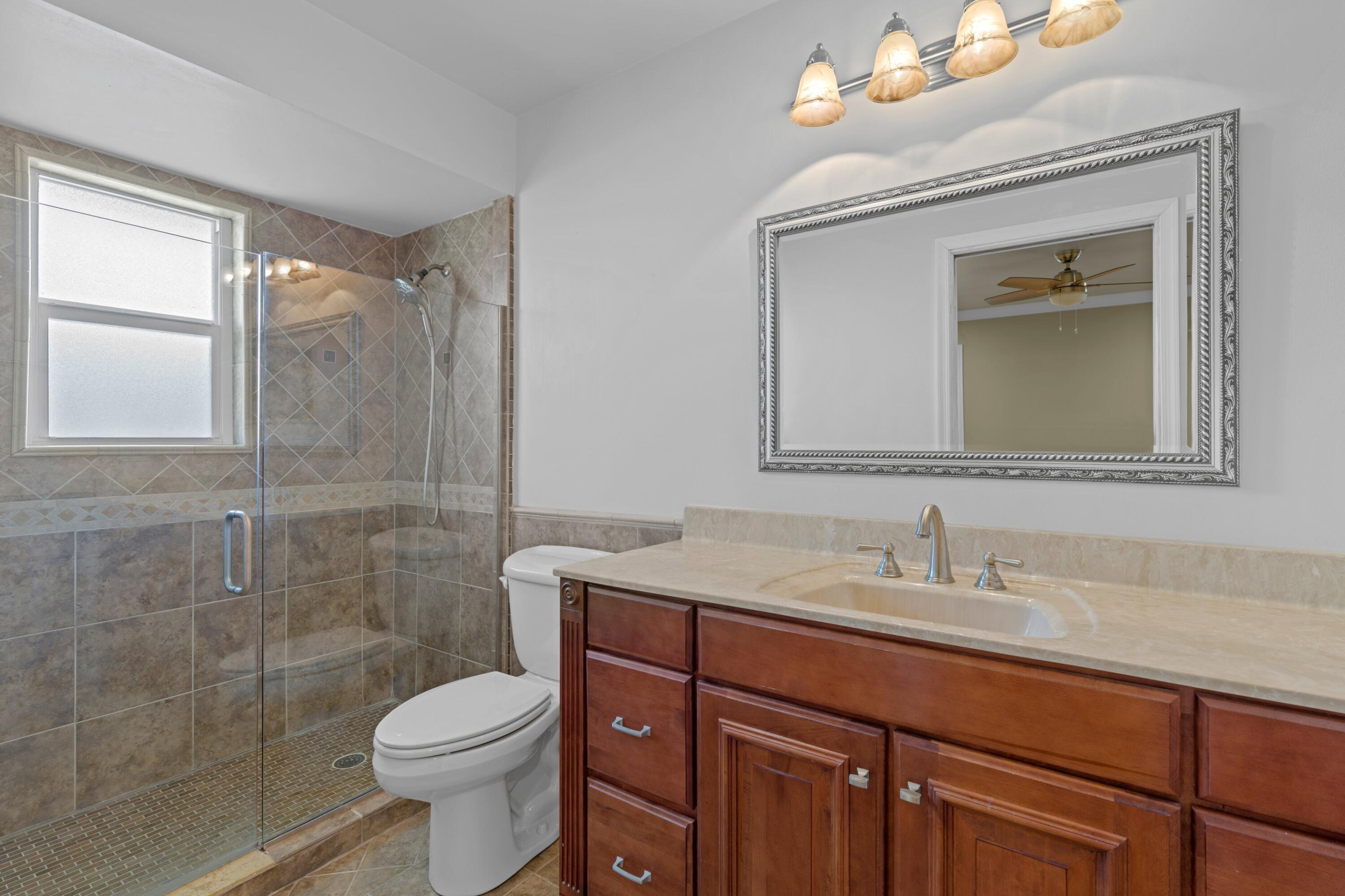 18312 Southeast Eagle Lane Jupiter, FL 33469 - Photo 12 of 17 a bathroom with a sink vanity mirror and toilet