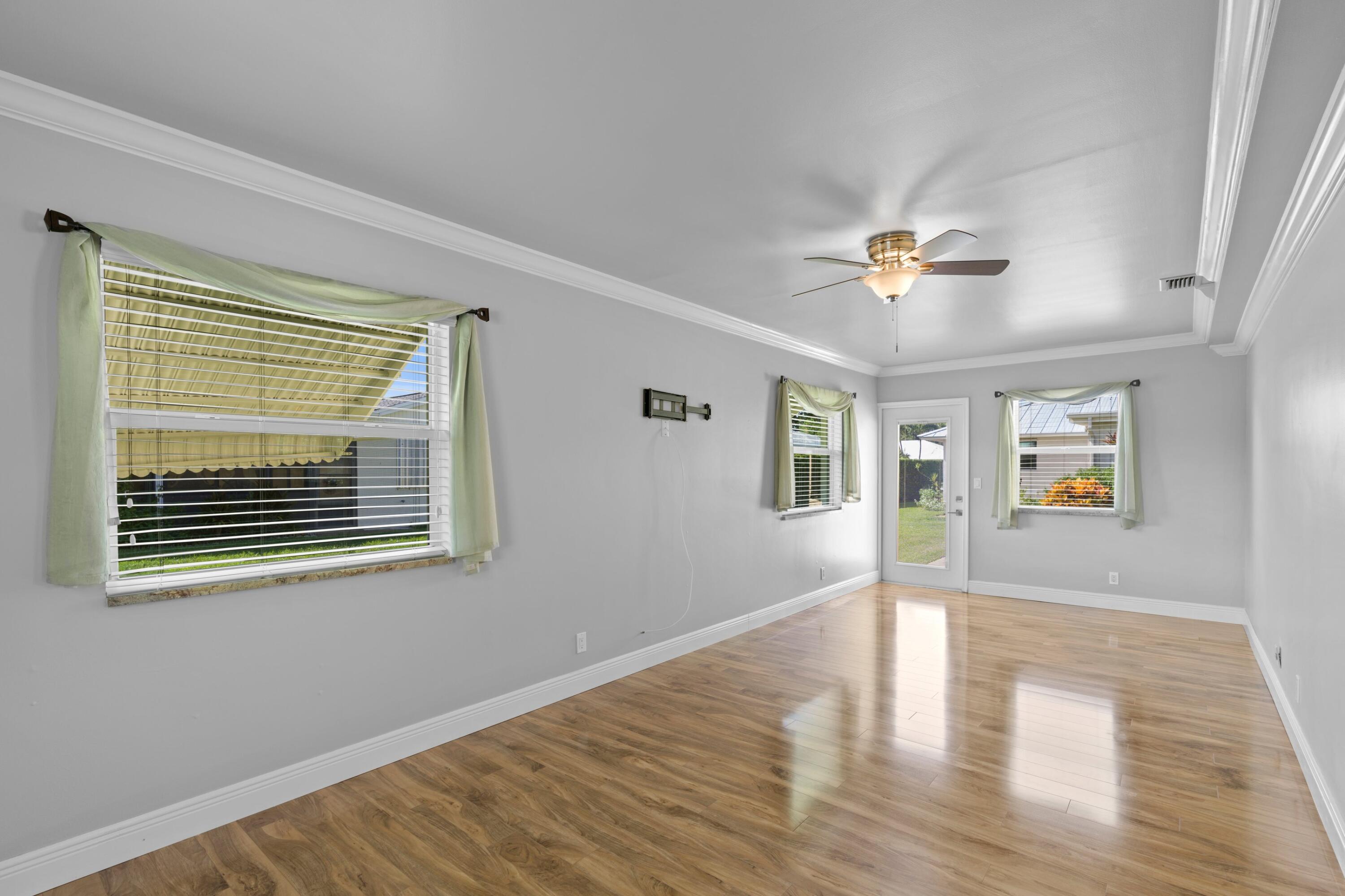 18312 Southeast Eagle Lane Jupiter, FL 33469 - Photo 8 of 17 a view of an empty room with a window and wooden floor