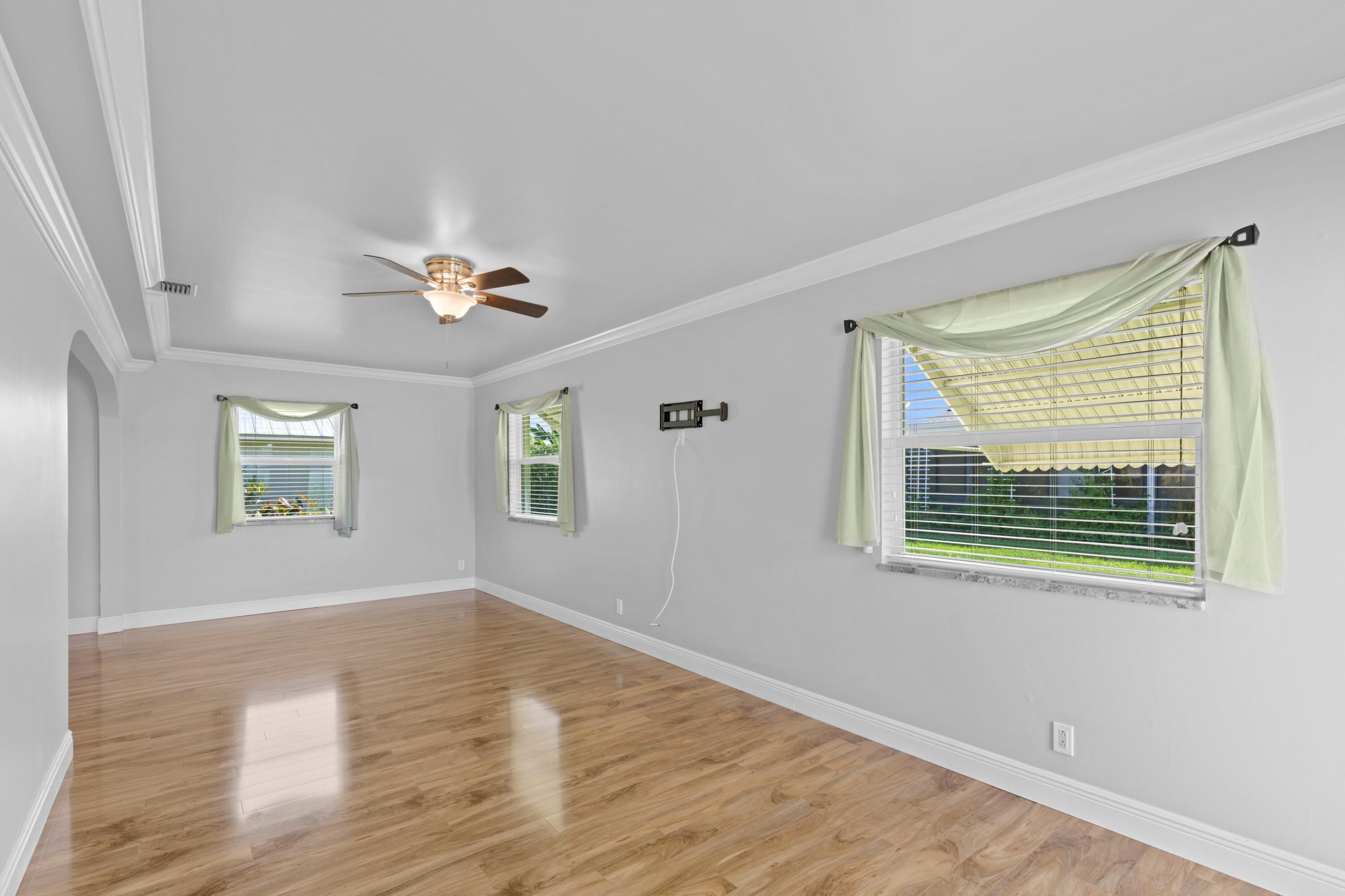 18312 Southeast Eagle Lane Jupiter, FL 33469 - Photo 9 of 17 a view of an empty room with wooden floor and a window