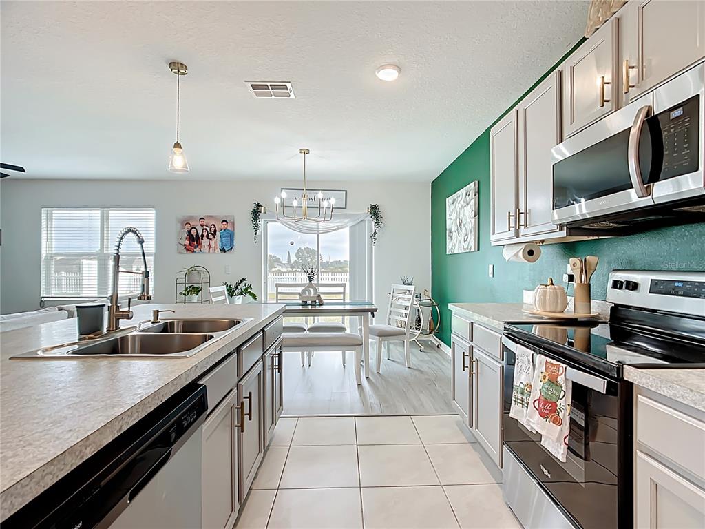 605 Honey Bell Road Winter Haven, FL 33880 - Photo 17 of 71 a kitchen with stainless steel appliances a sink a stove and cabinets