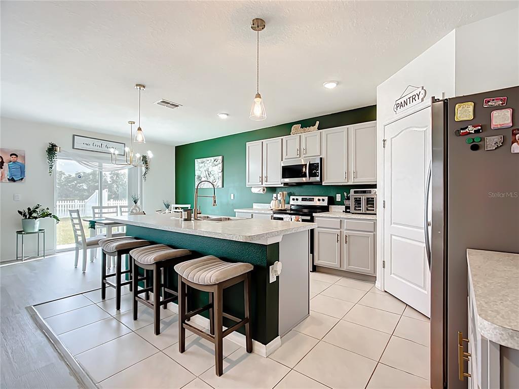 605 Honey Bell Road Winter Haven, FL 33880 - Photo 17 of 73 a kitchen with kitchen island granite countertop stainless steel appliances a sink a counter top space cabinets and a dining table