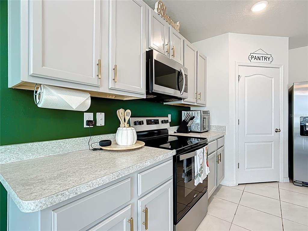 605 Honey Bell Road Winter Haven, FL 33880 - Photo 19 of 71 a kitchen with stainless steel appliances granite countertop a stove and a white cabinets