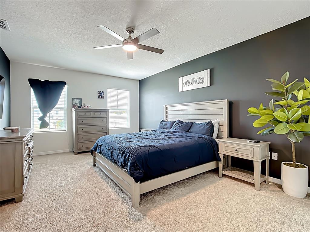 605 Honey Bell Road Winter Haven, FL 33880 - Photo 38 of 73 a spacious bedroom with a bed and a chandelier