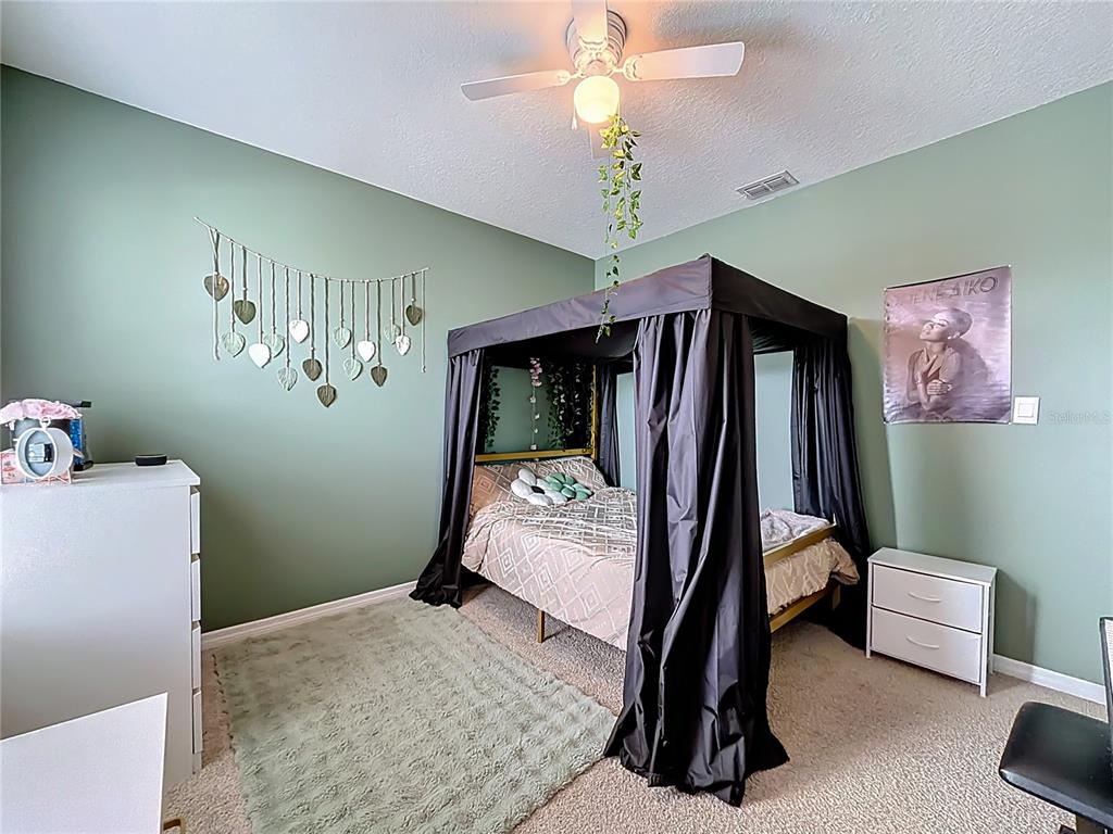 605 Honey Bell Road Winter Haven, FL 33880 - Photo 60 of 73 a bedroom with a bed and a chandelier