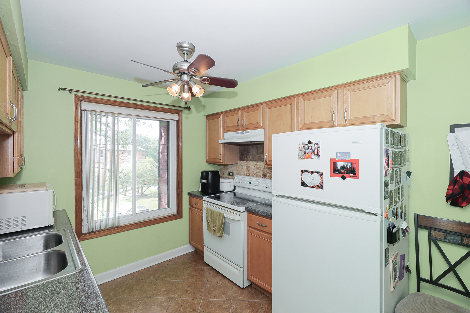 744 Briar Hill Lane, Unit 5 Addison, IL 60101 - Photo 5 of 20 a white kitchen with a stove a refrigerator and a window