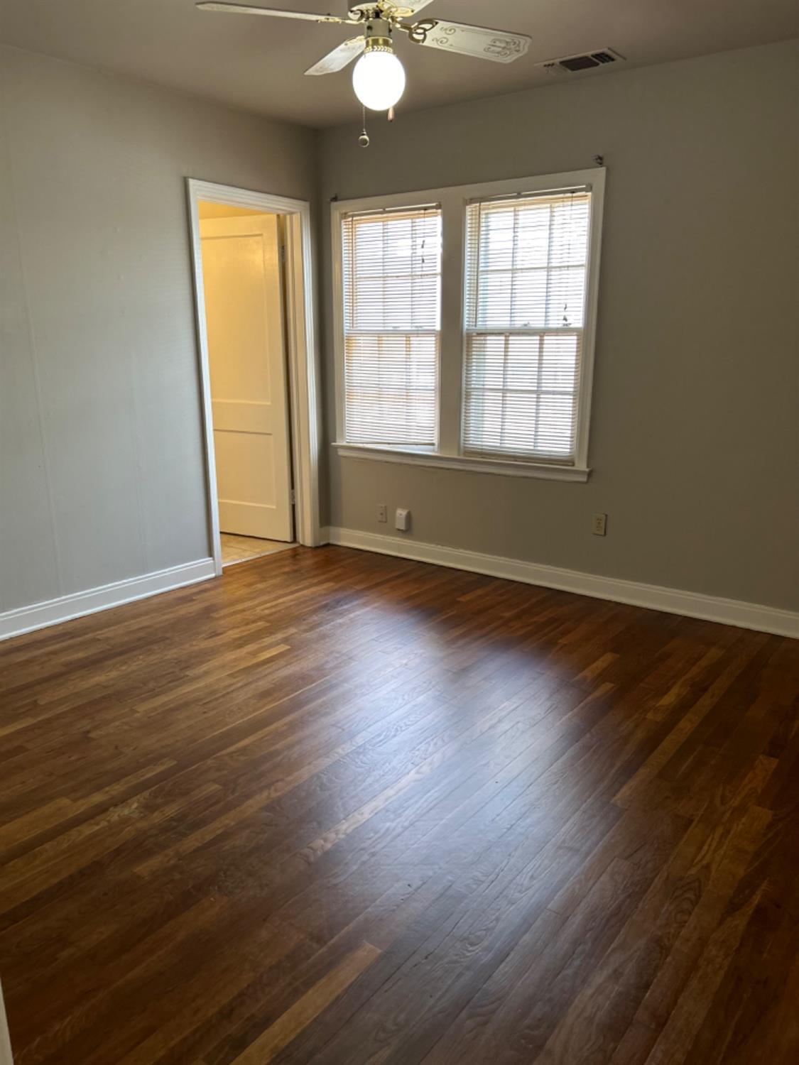 2818 27th Street Lubbock, TX 79410 - Photo 4 of 7 an empty room with wooden floor and windows